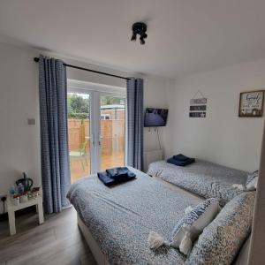 a bedroom with two beds and a sliding glass door at The Wight House B&B in Ryde