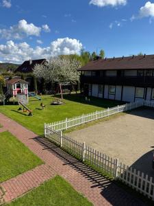 un parque con una valla blanca y un parque infantil en Dom Gościnny Marzena, en Międzyzdroje