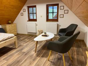 a room with two chairs and a table and a bed at Apartmán u rybníka in Sobotín