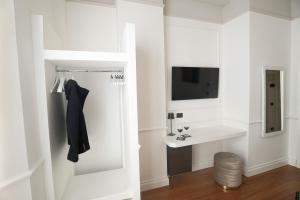 W białej łazience znajduje się umywalka i lustro. w obiekcie Rechigi Park Hotel w mieście Modena