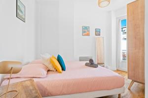 a bedroom with a bed with pink sheets and pillows at Terrasse des Oliviers in Nice