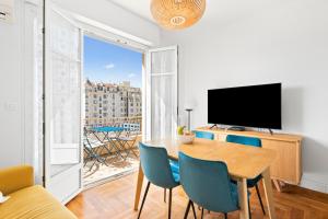 a living room with a table and chairs and a television at Terrasse des Oliviers in Nice