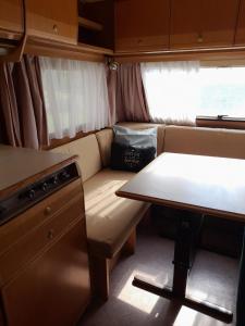 ein Wohnzimmer mit einem Tisch und einem Sofa in der Unterkunft Kamping, trailer Molly in Ulcinj
