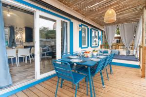 una mesa azul y sillas en una terraza con patio en Maïana Resort en La Grande-Motte