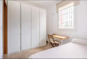 1 dormitorio con escritorio, 1 cama y ventana en Acogedor y precioso apartamento en Sevilla, en Sevilla