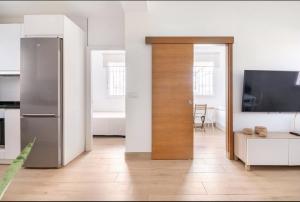 セビリアにあるAcogedor y precioso apartamento en Sevillaのリビングルームにつながるドア付きのキッチン