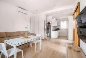 セビリアにあるAcogedor y precioso apartamento en Sevillaのリビングルーム(白いテーブル、ソファ付)