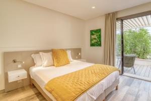a bedroom with a bed and a large window at Akwabay - Les Villas du Cap in Le Lavandou
