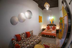 1 dormitorio con 1 cama y 1 sofá en una habitación en Riad Sekaya Fez en Fez