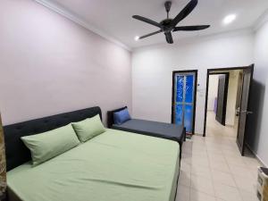 a bedroom with a bed and a ceiling fan at Garden Homestay in Kulai