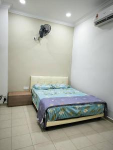 a bedroom with a bed with a fan on the wall at Garden Homestay in Kulai