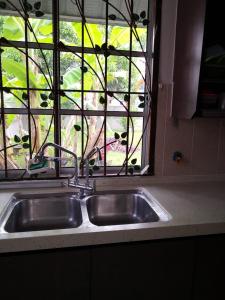 een aanrecht met een raam met uitzicht bij Garden Homestay in Kulai
