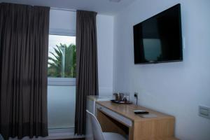 a room with a desk and a television on the wall at Hotel Belgrano in San Luis