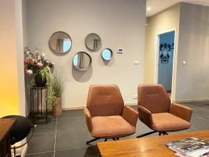 a waiting room with two chairs and mirrors on the wall at In de Witte Dame Hotel Bar Kitchen Apartments in Grubbenvorst