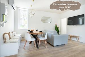 a living room with a table and chairs and a couch at Sariette - Spacieux - Linge hôtelier - Fibre - Confort in La Destrousse