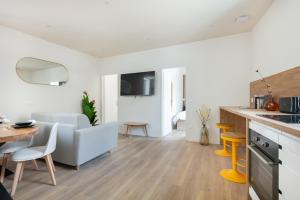 a kitchen and living room with a couch and a table at Sariette - Spacieux - Linge hôtelier - Fibre - Confort in La Destrousse