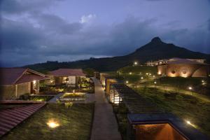 een uitzicht op een resort 's nachts met een berg bij Resort Amanzi in Lonavala