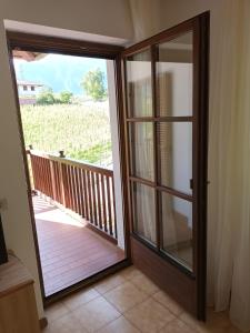 a door to a balcony with a view of a field at Dolcevita apartments in Lavis