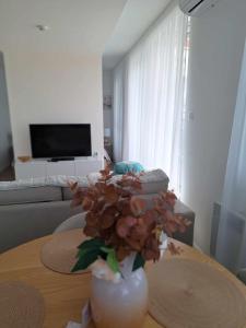 wazon z kwiatami na stole w salonie w obiekcie DIAMOND - Luxusný Apartmán Marco w mieście Podhájska