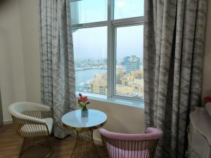 um quarto com uma mesa e cadeiras e uma janela em شقة فخمة وواسعة غرفتين luxury and big 2BR em Ajman