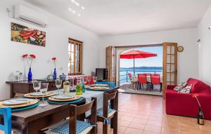 uma sala de jantar com uma mesa e vista para o oceano em 3 Bedroom Awesome Apartment In Jablanac em Jablanac