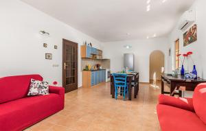 a living room with a red couch and a dining room at Amazing Apartment In Jablanac in Jablanac