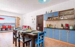 a kitchen and dining room with a table and blue cabinets at Amazing Apartment In Jablanac in Jablanac