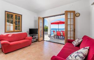 uma sala de estar com mobiliário vermelho e vista para o oceano em 3 Bedroom Awesome Apartment In Jablanac em Jablanac
