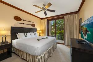 Un dormitorio con una cama grande con ventilador de techo. en Ko Olina Beach Villas B107, en Kapolei 39 fotos más