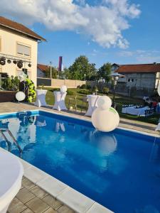 una piscina con sedie bianche e una piscina di Villa Mia a Prnjavor