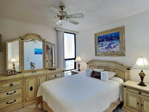 a bedroom with a bed and a dresser and a mirror at Oceans Atrium 205 in Daytona Beach Shores