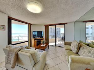 a living room with a couch and a tv at Oceans Atrium 205 in Daytona Beach Shores