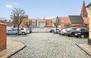 un estacionamiento con un montón de coches aparcados en 1 Bedroom Cozy Home In Rnne, en Rønne