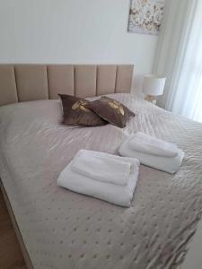 duas toalhas numa cama com duas almofadas em DIAMOND - Luxusný Apartmán Marco em Podhájska