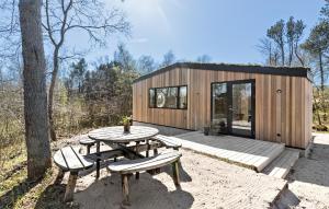 een kleine houten hut met een picknicktafel en banken bij Amazing Home In Grenaa With Kitchen in Grenå