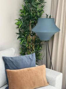une lampe bleue assise à côté d'un canapé avec un oreiller dans l'établissement Countryside 2 bed cottage- Aylesbury, à Haddenham