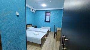 a room with two beds and a blue wall at Volidam Hotel in Karmana
