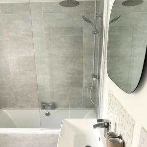 a bathroom with a tub and a sink and a mirror at Countryside 2 bed cottage- Aylesbury in Haddenham +32 photos