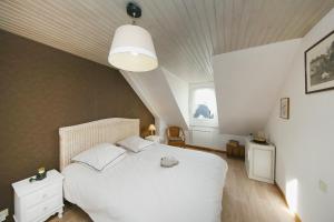 ein Schlafzimmer mit einem weißen Bett und einem Fenster in der Unterkunft Maison Lutène - Avec jardin terrasse in Sartilly