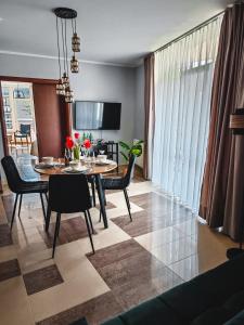a dining room and living room with a table and chairs at Ava Relax Apartments in Świnoujście