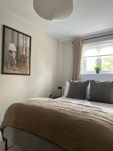 a bedroom with a bed and a picture of a person with an umbrella at Countryside 2 bed cottage- Aylesbury in Haddenham