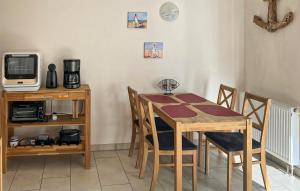 uma sala de jantar com mesa e cadeiras e uma televisão em 1 Bedroom Stunning Apartment In Graal-mritz ostseehe em Graal-Müritz