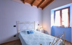 een slaapkamer met een bed met blauwe muren en een raam bij Gorgeous Apartment In Borgo A Mozzano With Wifi in Borgo a Mozzano