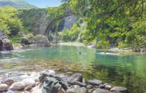 um rio com pessoas nadando na água sob uma ponte em Nice Apartment In Borgo A Mozzano em Borgo a Mozzano