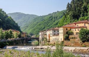 uma ponte sobre um rio numa cidade com montanhas em Nice Apartment In Borgo A Mozzano em Borgo a Mozzano mais 29 fotografias