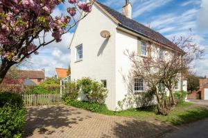 a white house with a fence in front of it at Annie's House in Thorpeness
