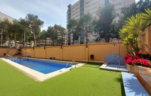 オロペサ・デル・マールにあるCozy Apartment In Oropesa Del Marの隣の緑の芝生のスイミングプール +12枚の写真
