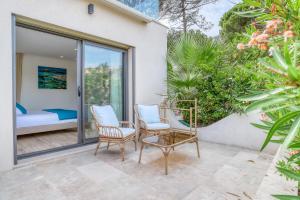 a patio with two chairs and a bed at Akwabay - Les Villas du Cap in Le Lavandou