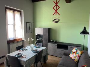 uma sala de jantar com uma mesa e um sofá em "Biancospino" Alloggio Turistico a Milano em Vimodrone