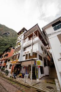 a white building with balconies on the side of it at DANNA INN in Machu Picchu